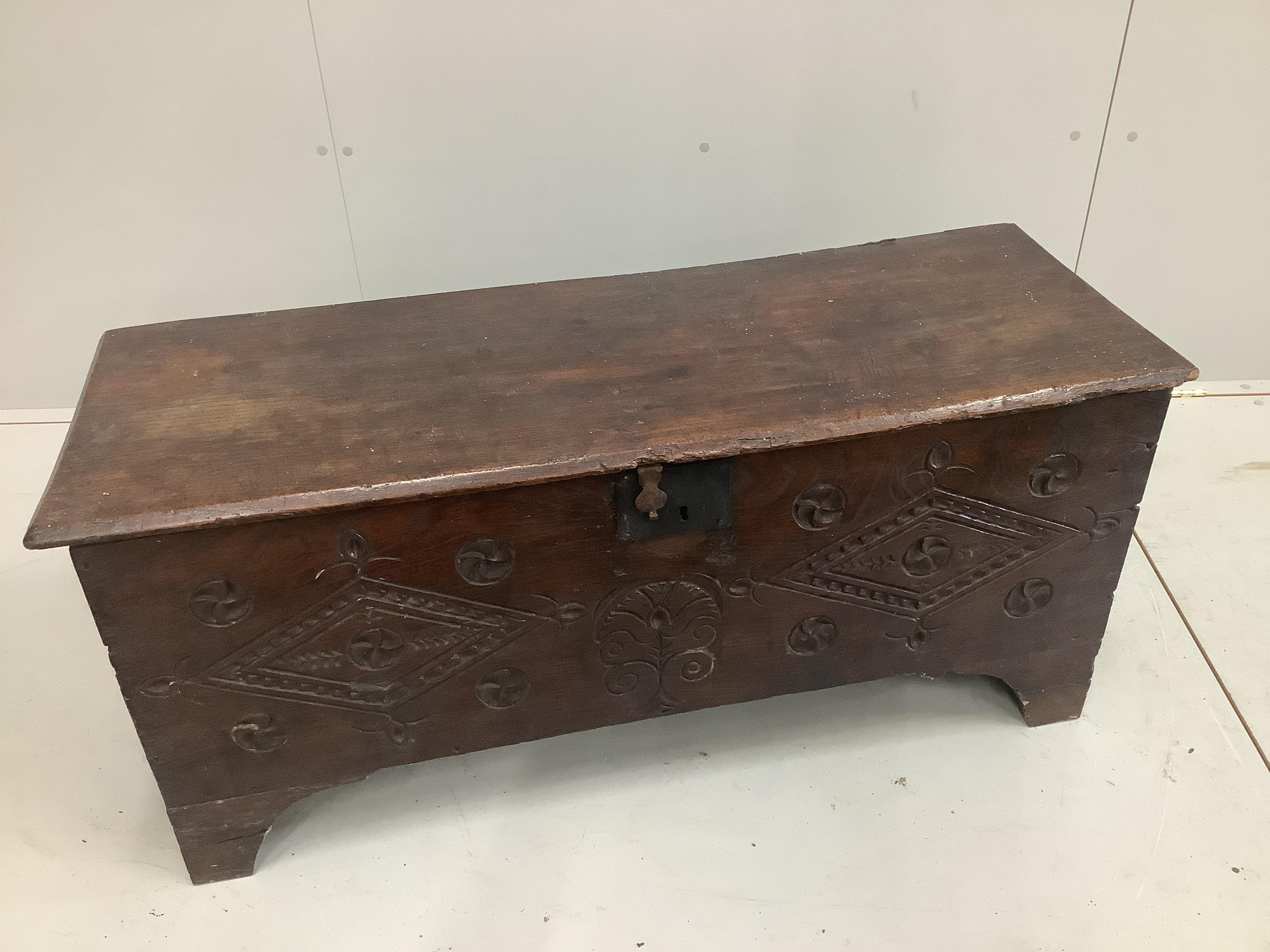 A 17th century style carved elm six plank coffer, width 112cm